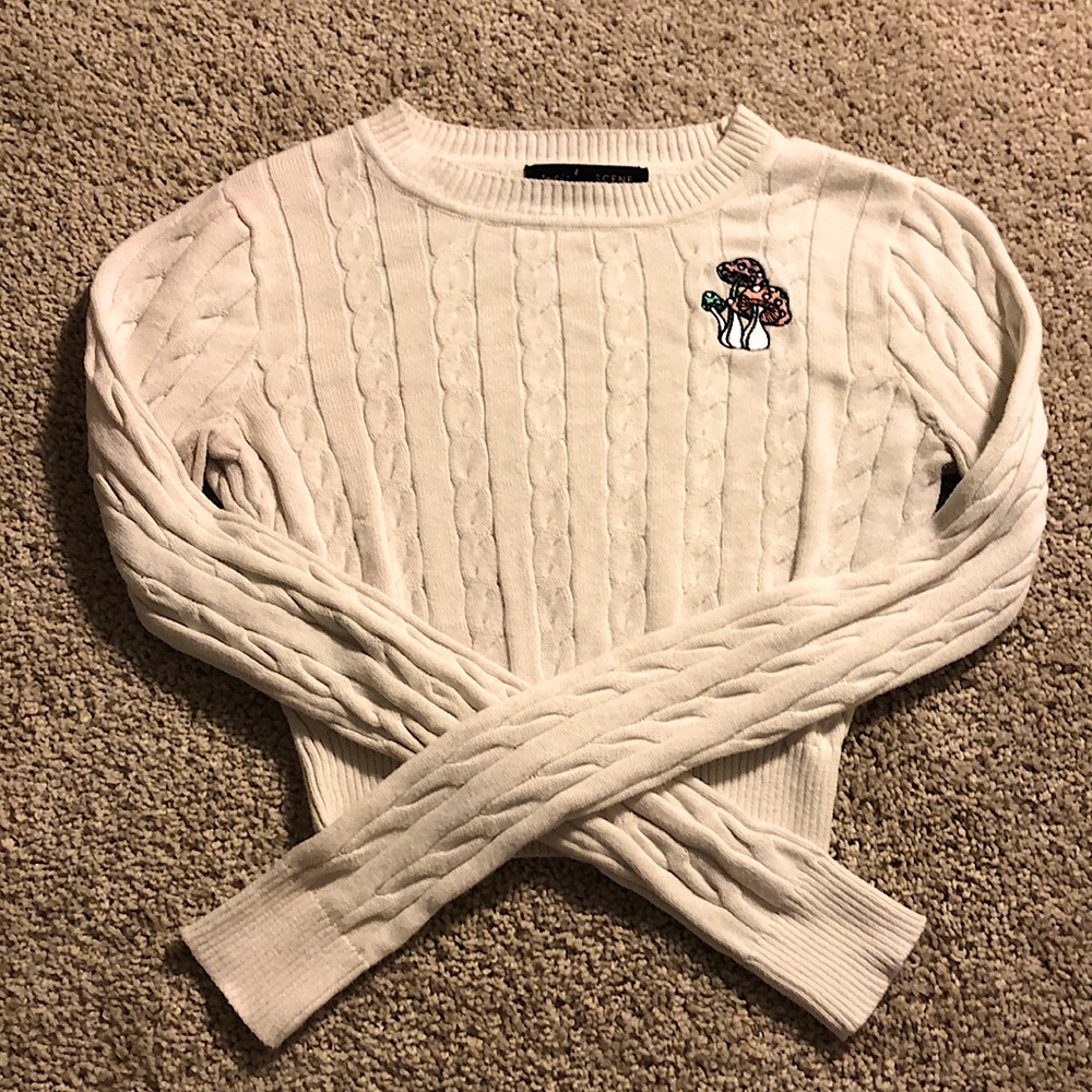 White cropped knit sweater with engraved mushrooms on shoulder.
